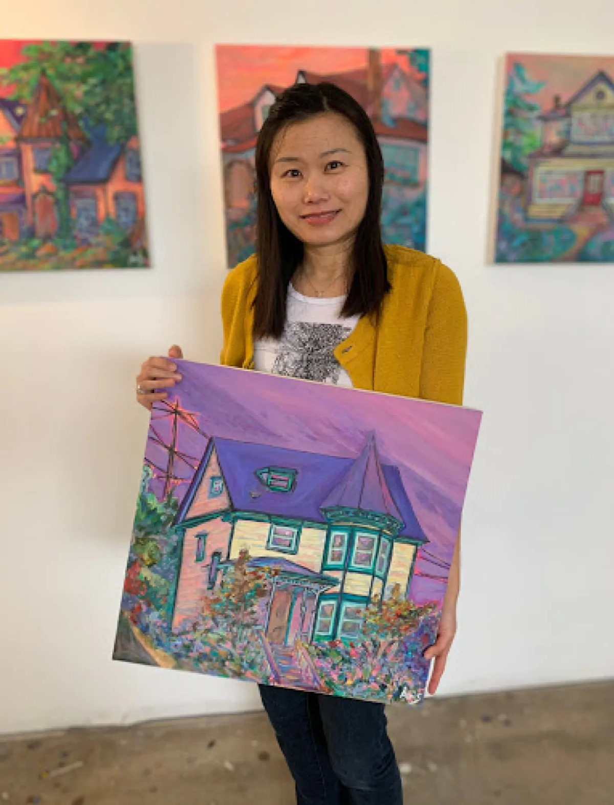 Aeris Osborne holding one of her paintings